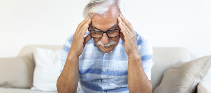 Attack of the monster migraine. Unhappy Retired Senior man holding his head with pain expression . Face of senior man suffering from headache